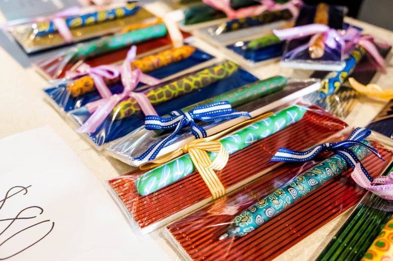 Bookmarks packaged with pens are displayed on a table, waiting to be sold.